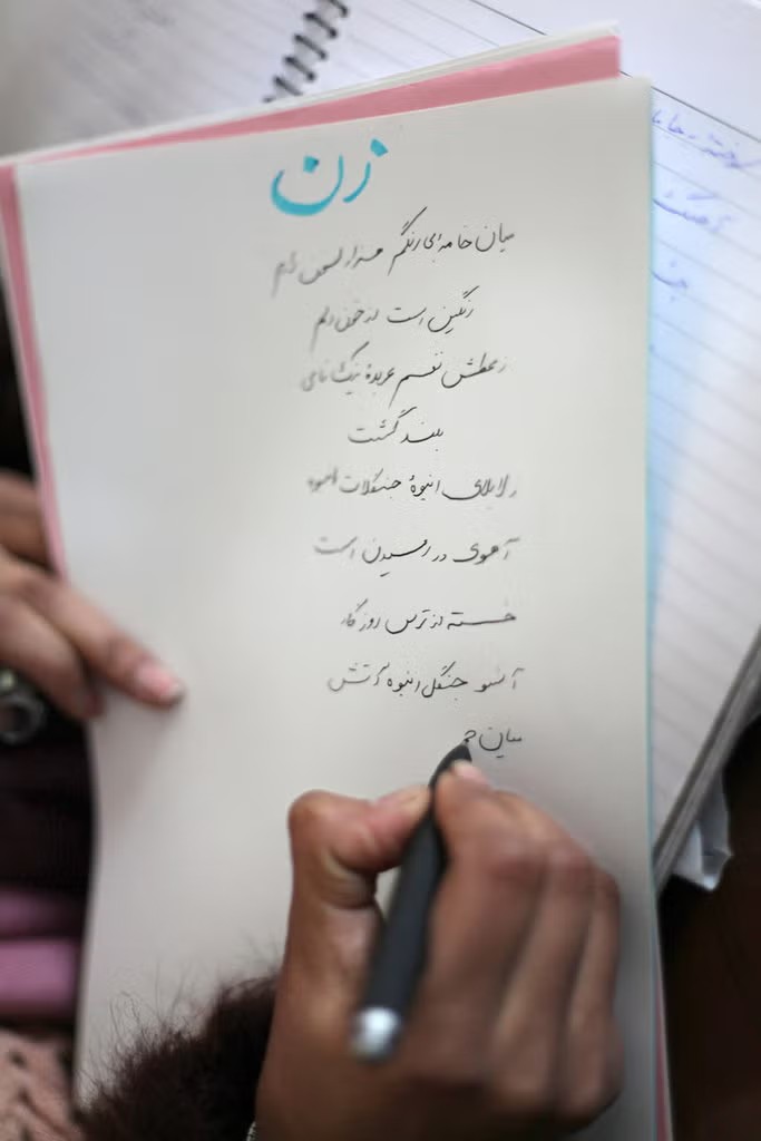 A woman writing a poem titled "Zan" (Woman) in Persian